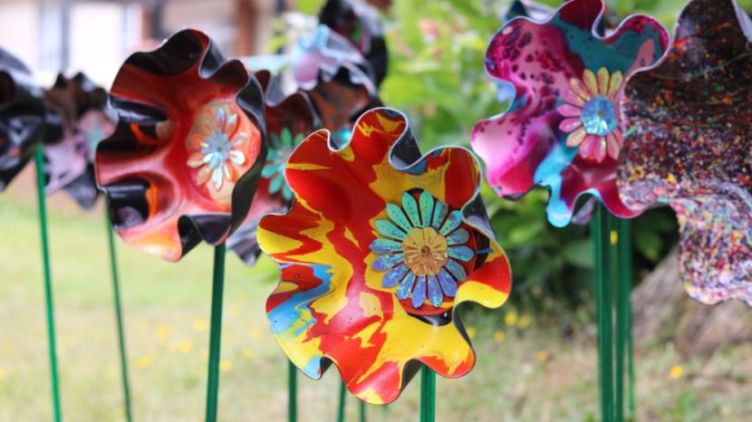 Flowers made out of vinyl records, painted and on stands.