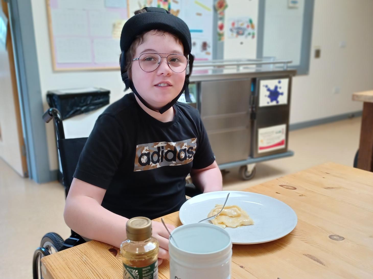 Riley with pancakes he has made in baking group