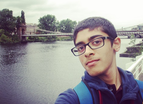 Abdullah takes a selfie in front of a river and bridge