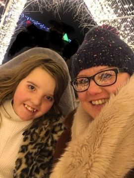 Daisy: young girl and her mum smile in front of christmas lights