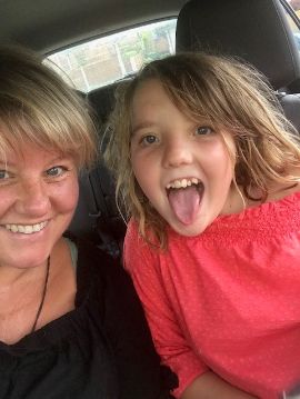Daisy: young girl sticks out her tongue, her mum smiles next to her