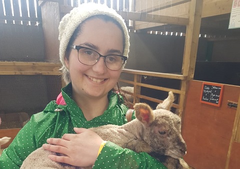 Rebekah: young girl smiles holding a lamb