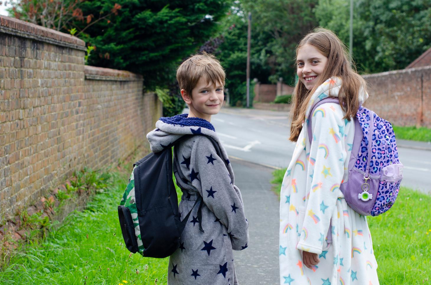 Children wearing dressing gowns and school bags