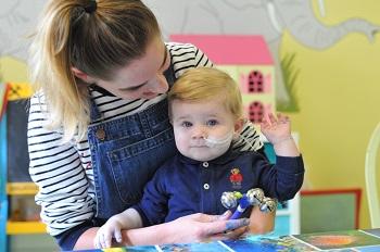 Arthur sitting with his mum Laura at The Children's Trust in 2018