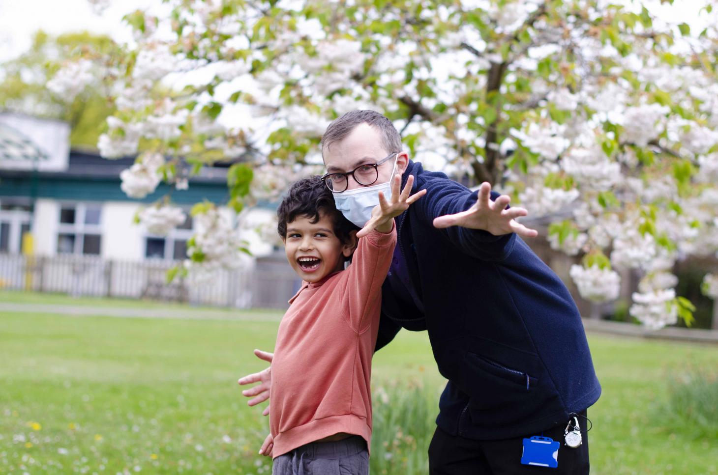 Nurse Matt stood outside at The Children's Trust posing with a young person to celebrate International Nurses Day