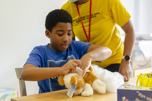 Aaron making a stuffed animal toy onsite at The Children's Trust 
