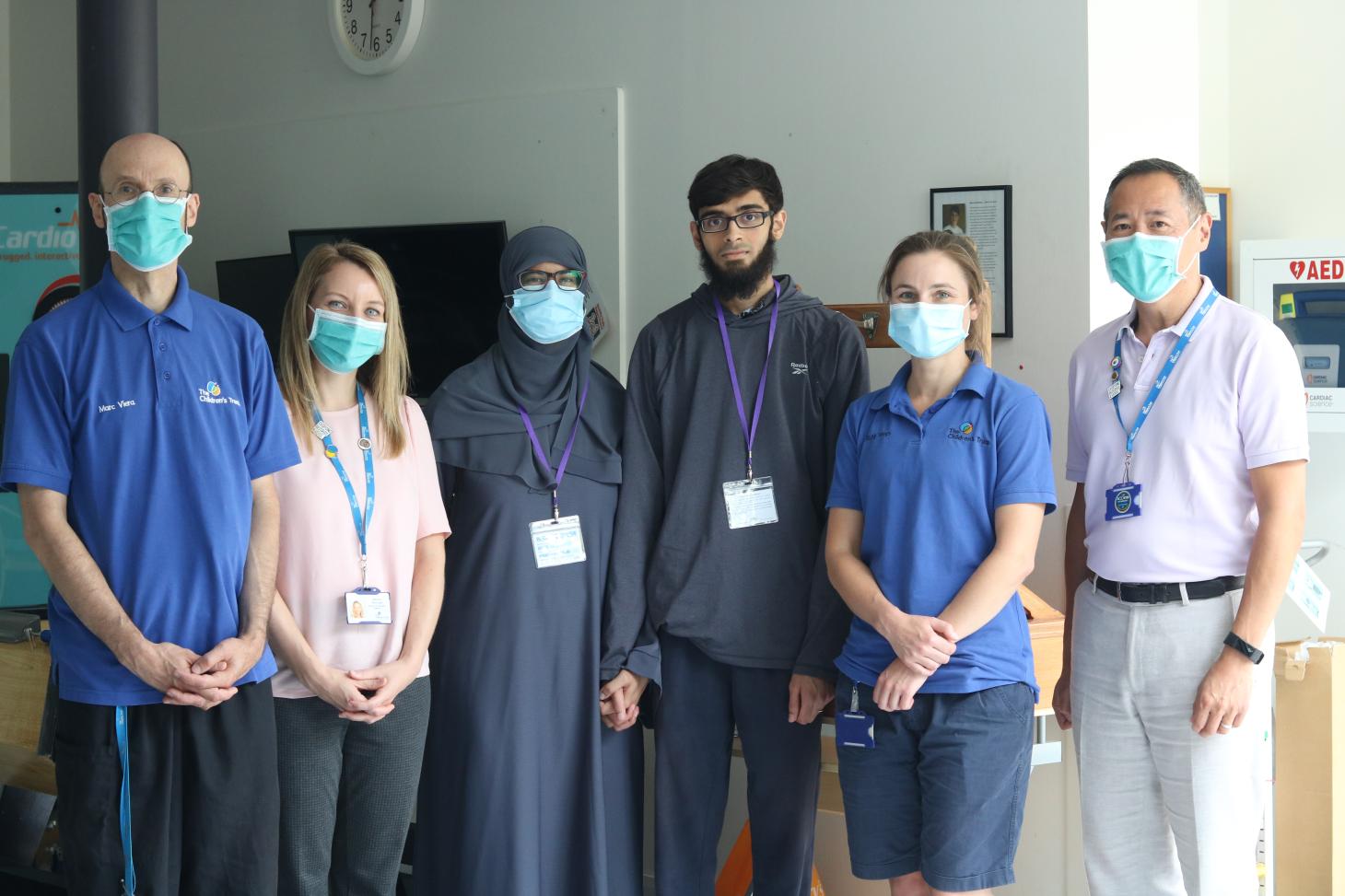 Abdullah standing with his wife and staff at The Children's Trust