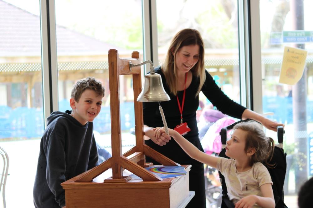 Lois ringing the bell surrounded by family