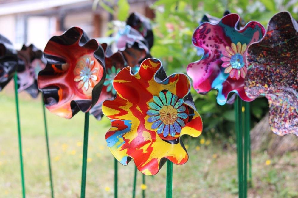 Flowers made out of vinyl records, painted and on stands.