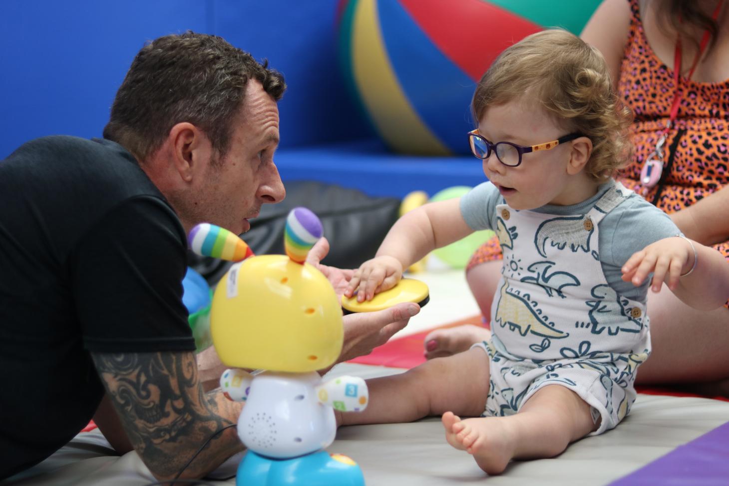 Teddie pressing a switch to activate a toy