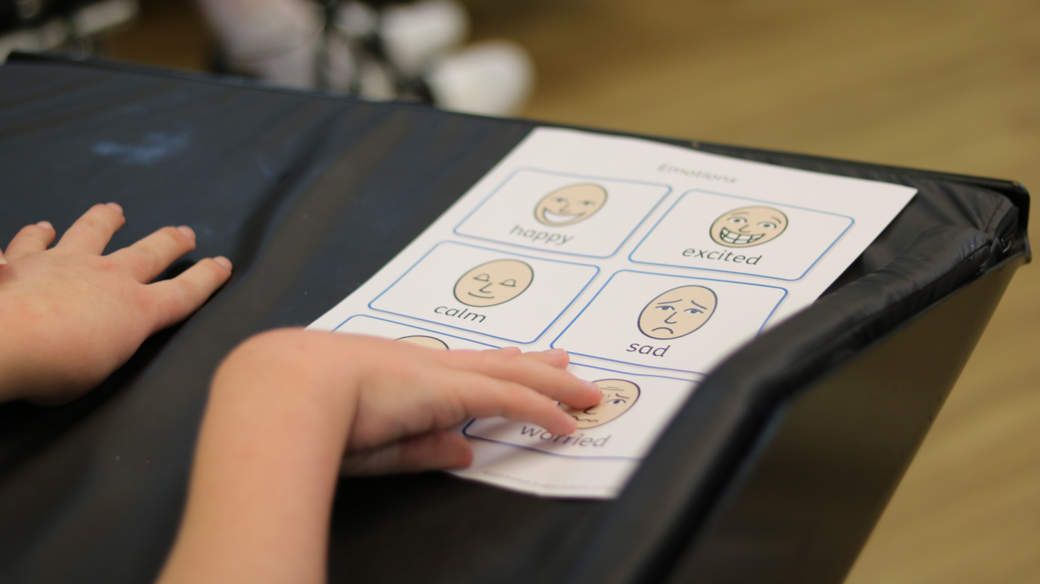 Child pointing to images of expressions