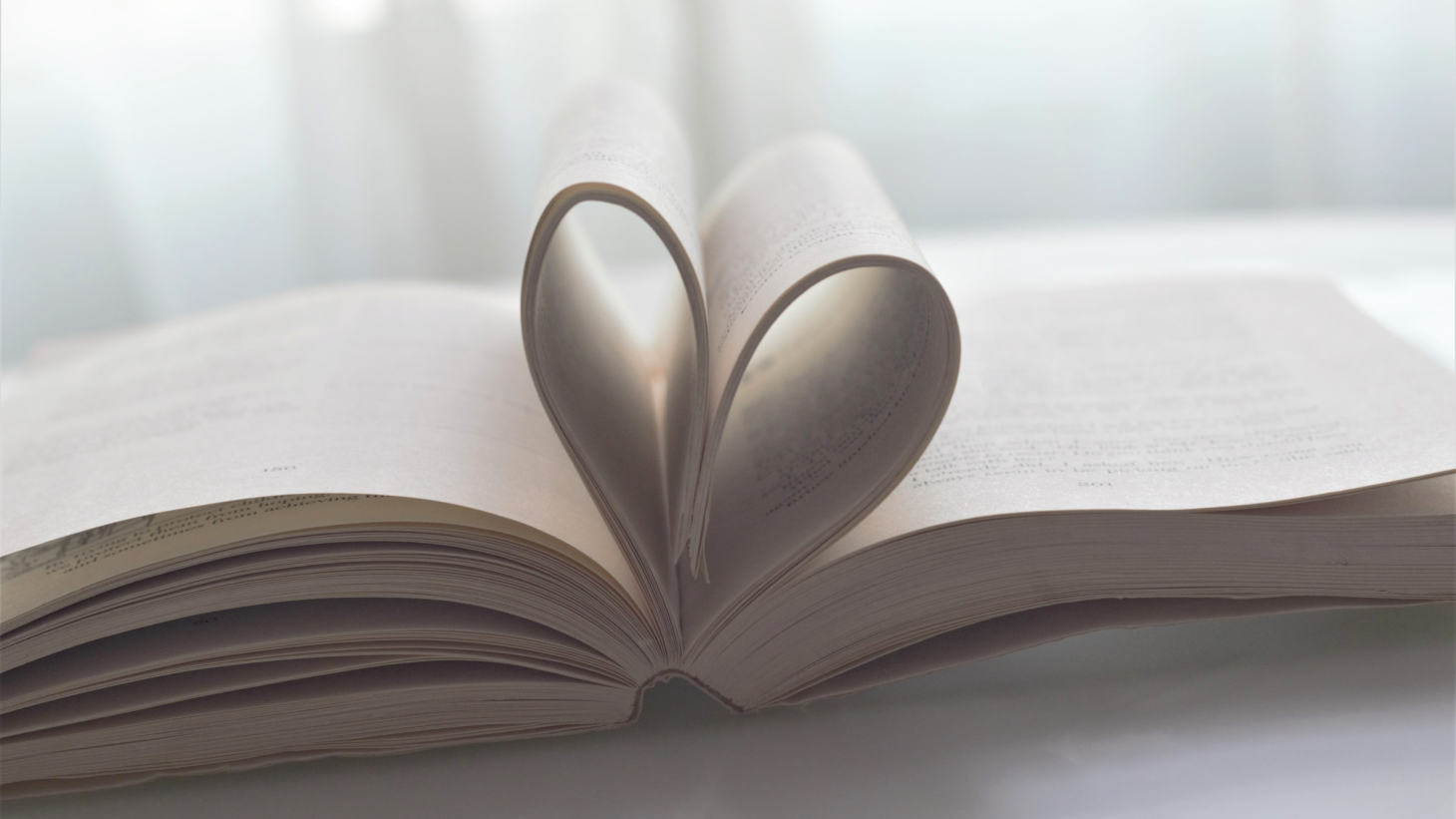 Pages of a book folded into the spine to create a shape of a heart.