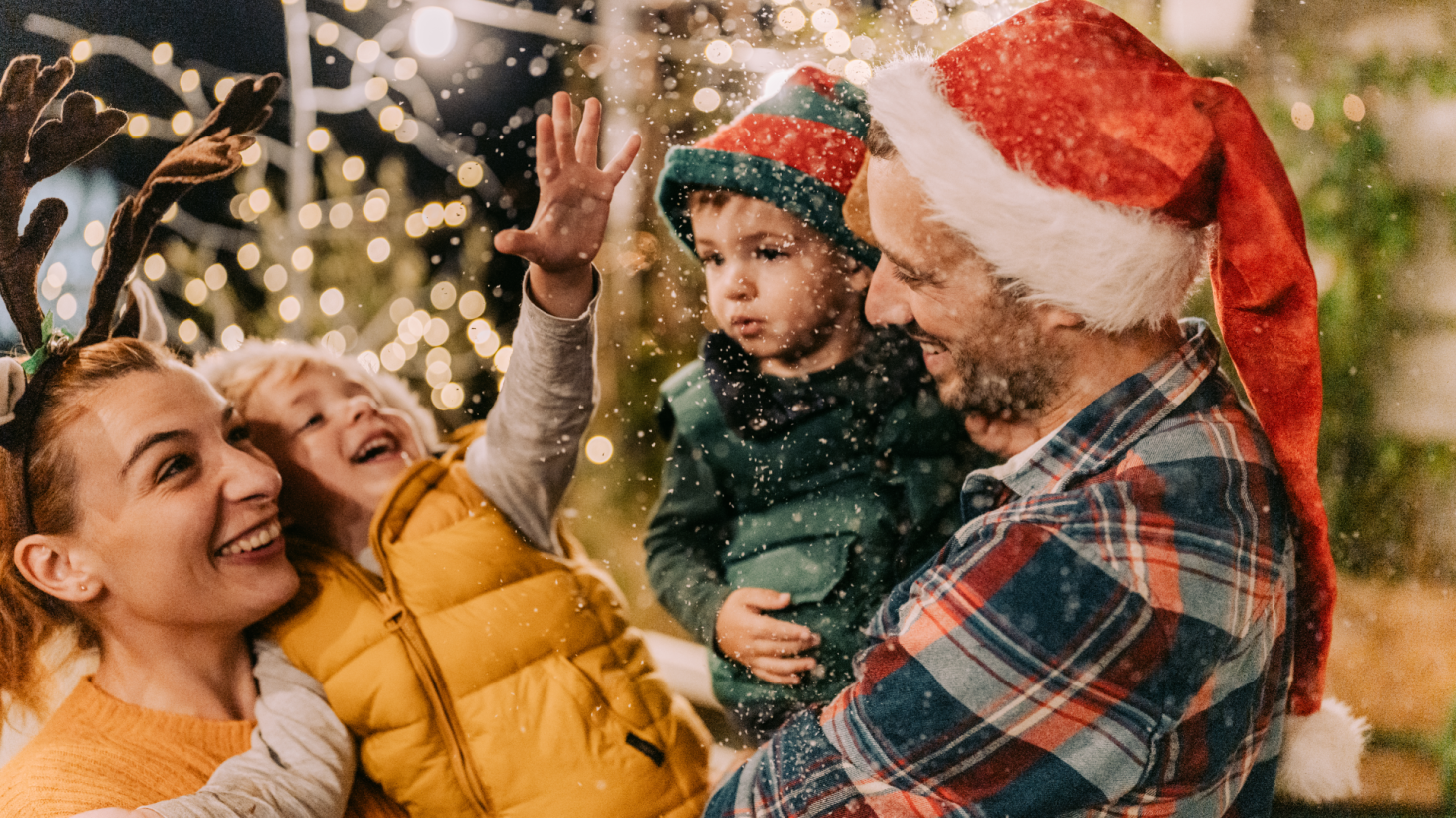 A family outdoors enjoying snow and winter festivities