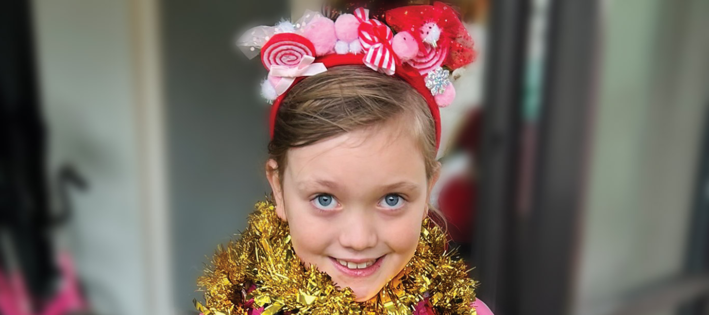 Violet wearing a tinsel scarf and smiling