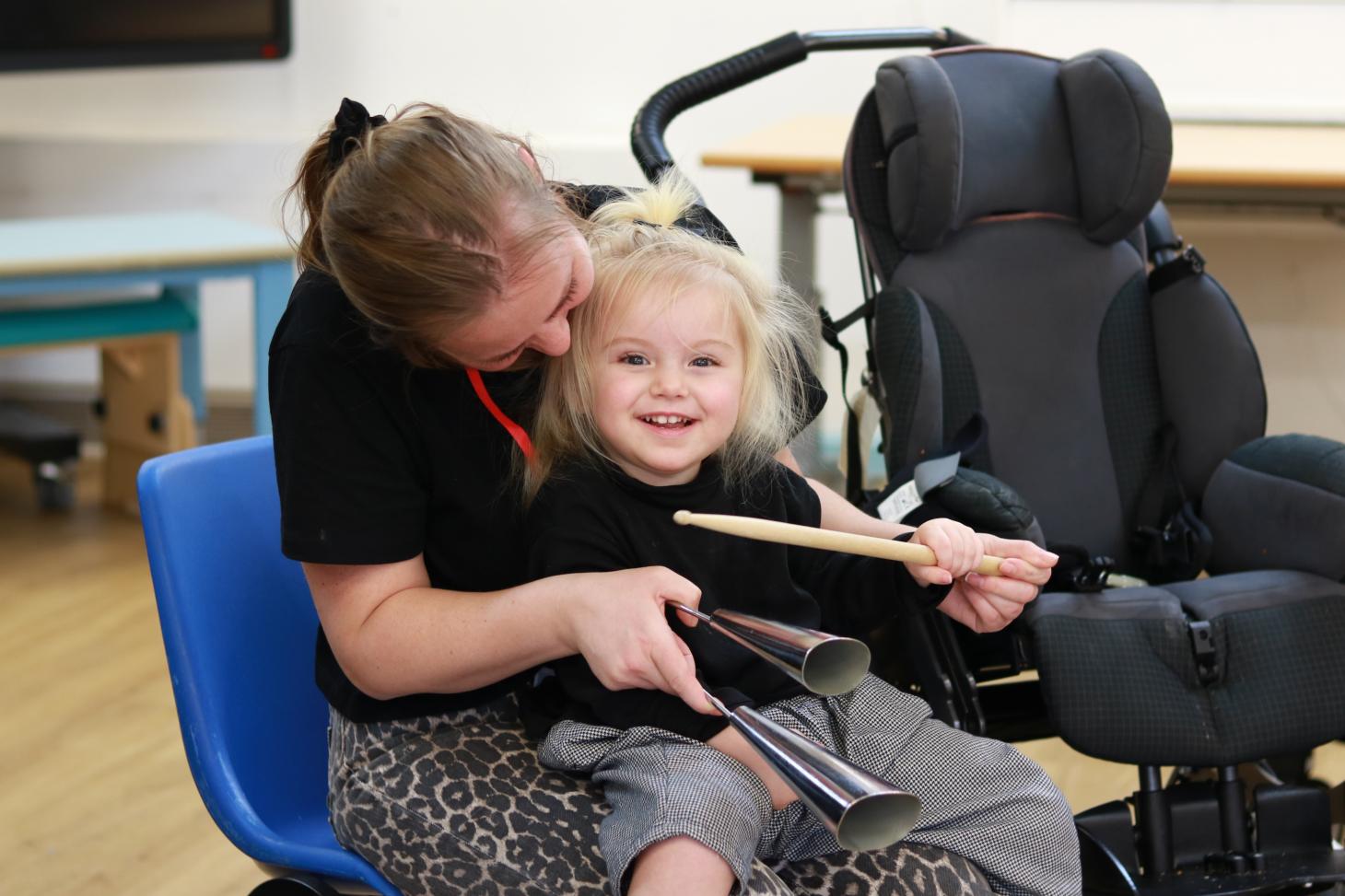 Liliana smiling playing a bell