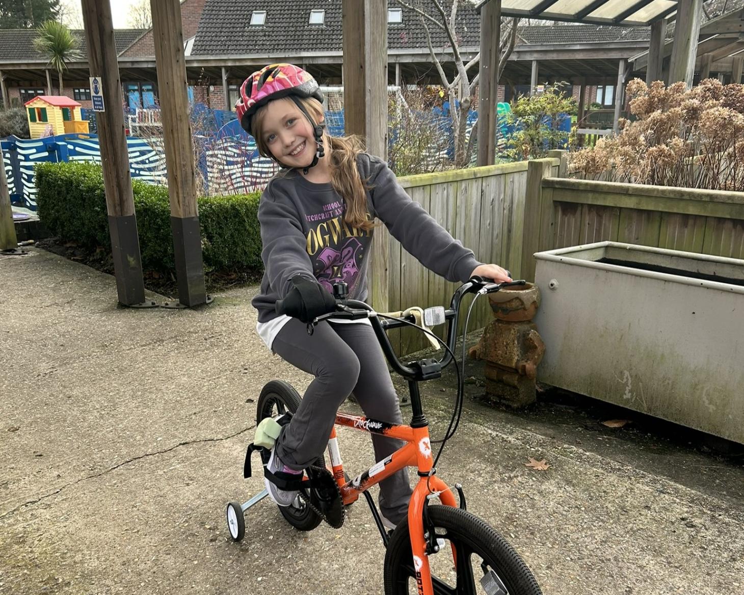 Violet on a bike at The Children's Trust