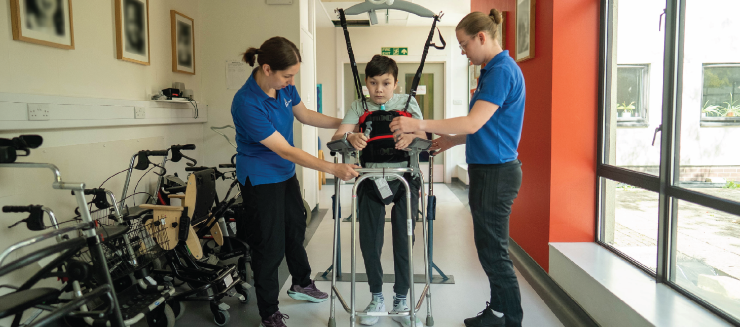 Leo in a therapy session using the Guldmann Hoist with therapists