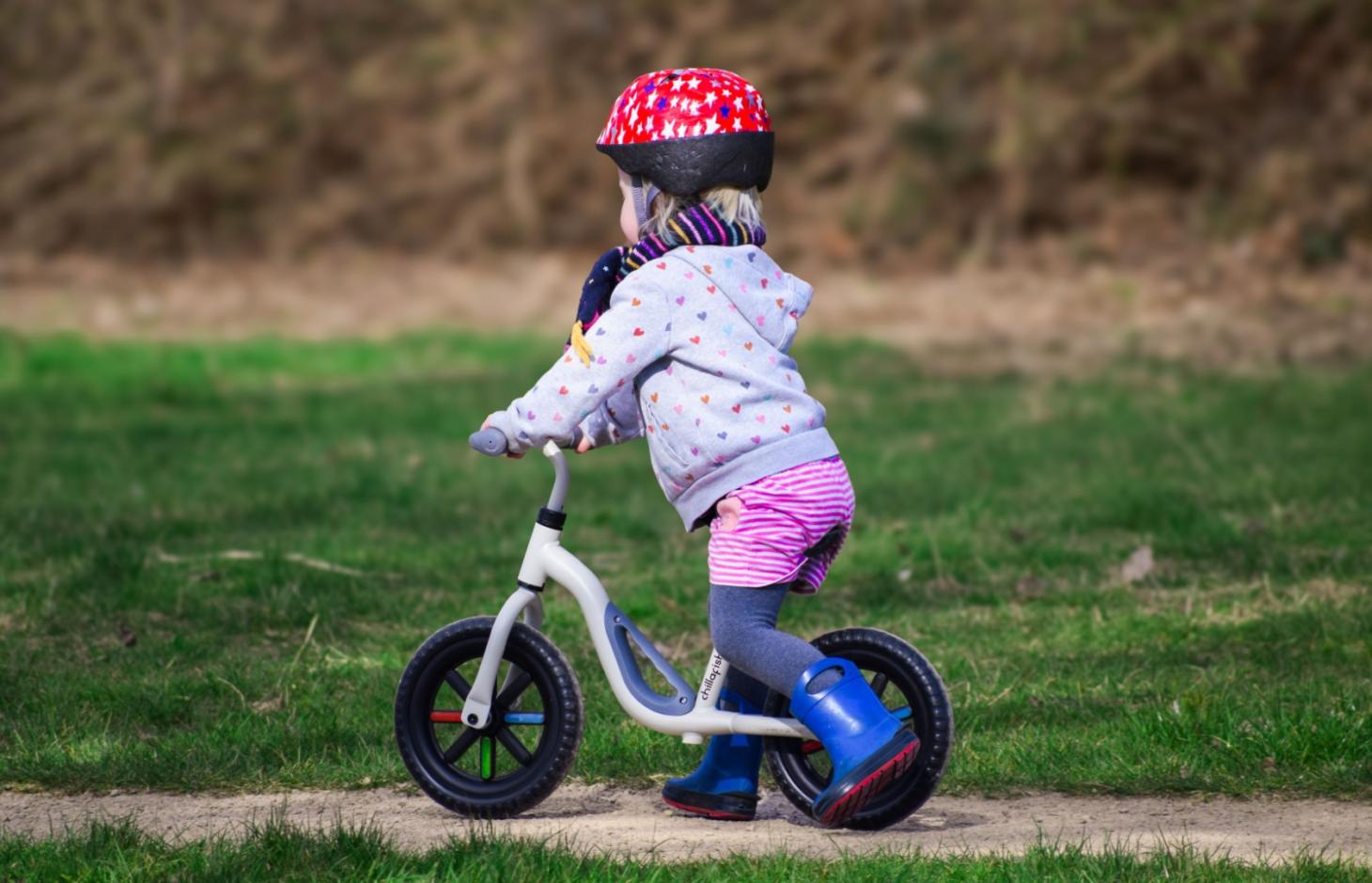 Toddler wearing helmet riding a bike