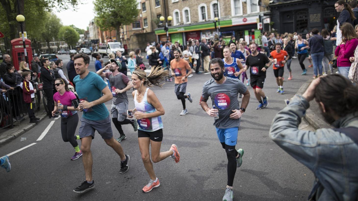 male and female runners on the street, happy and mid run