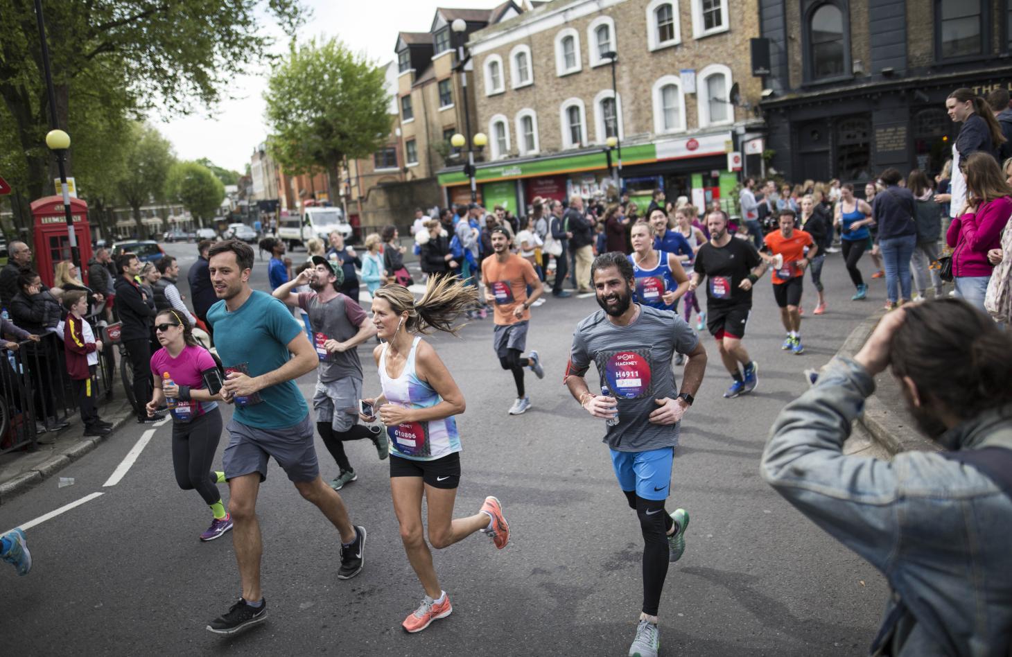 male and female runners on the street, happy and mid run