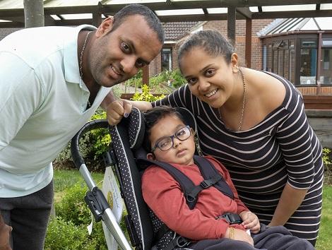 Kai and his parents: young boy in a wheelchair with his mum and dad