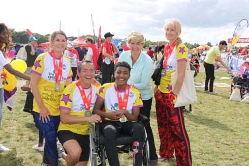 group of people wearing The Children's Trust t-shirts at the finish line of the Superhero Tri