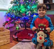Orion smiling in front of a Christmas tree