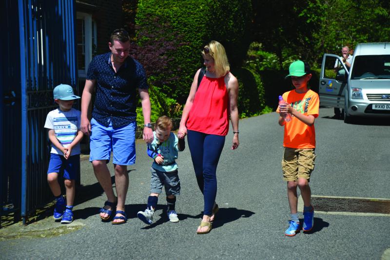 Josh walking out of The Children's Trust with his family