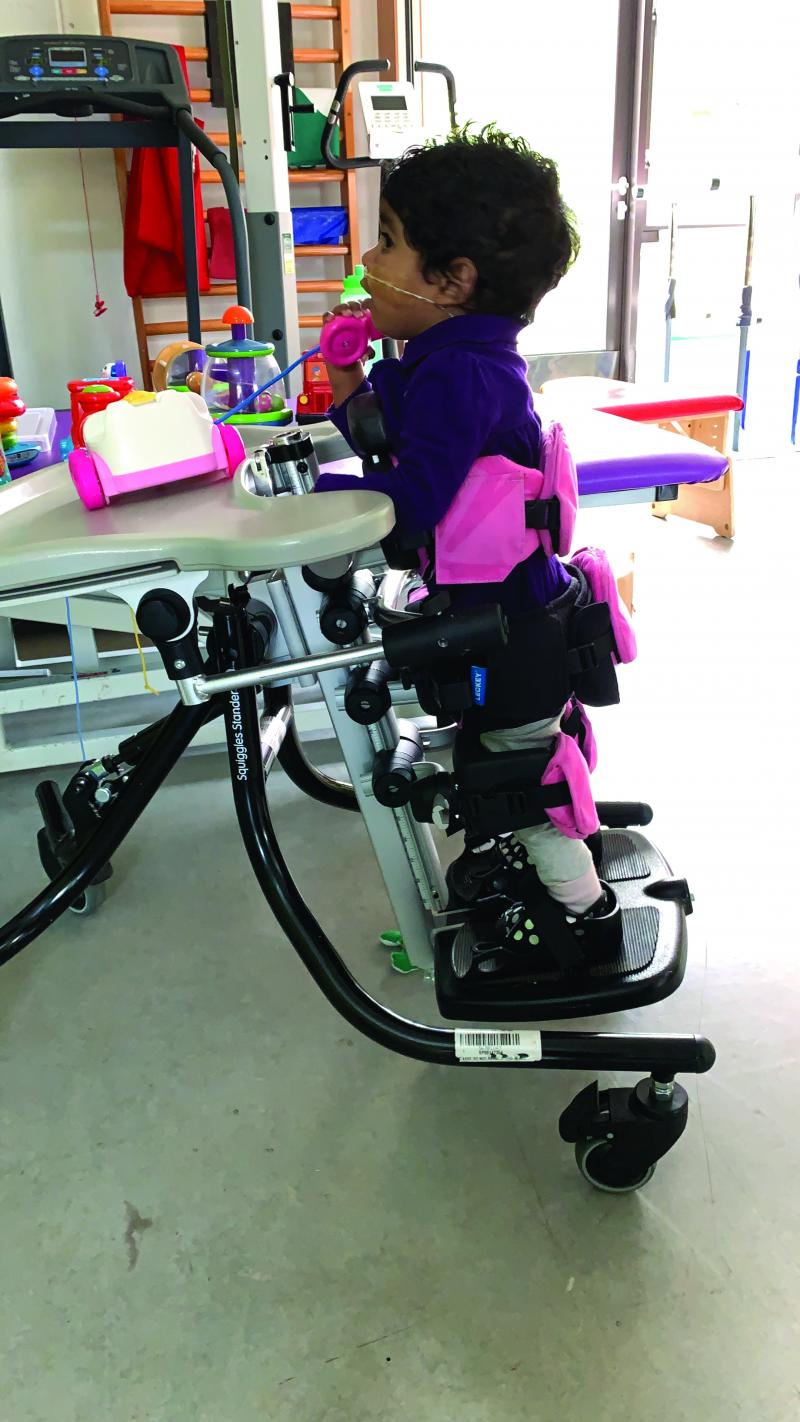 Saffron in a standing frame at The Children's Trust