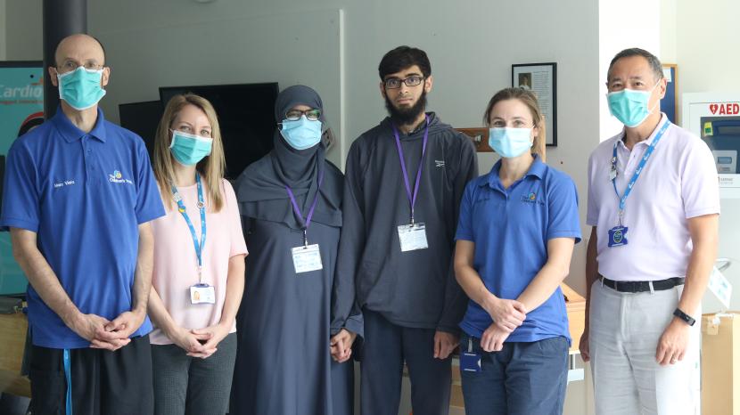 Abdullah standing with his wife and staff at The Children's Trust