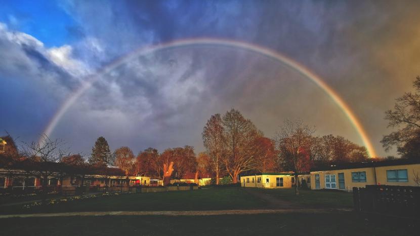 School building with rainbow in sky