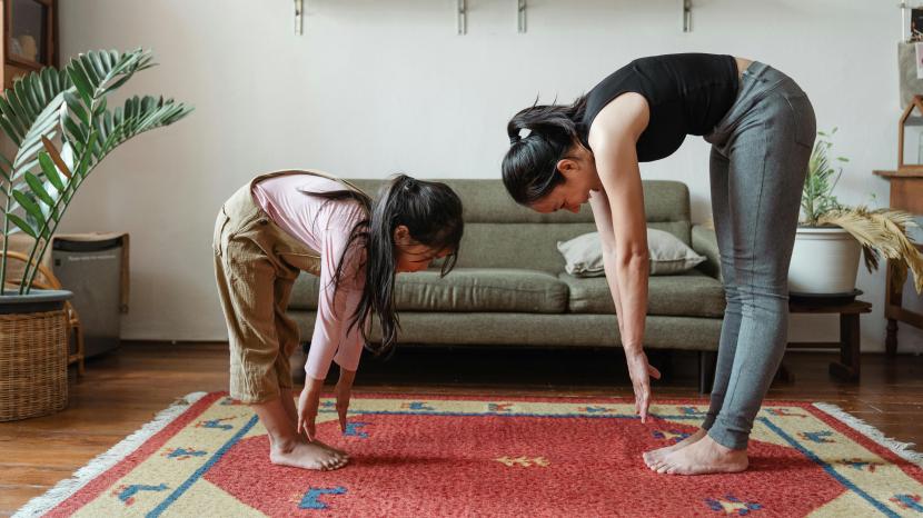 A mother and daughter practising yoga and stretching