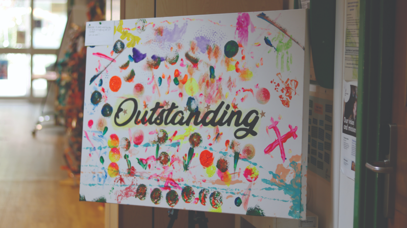 The word 'Outstanding' painted on canvas