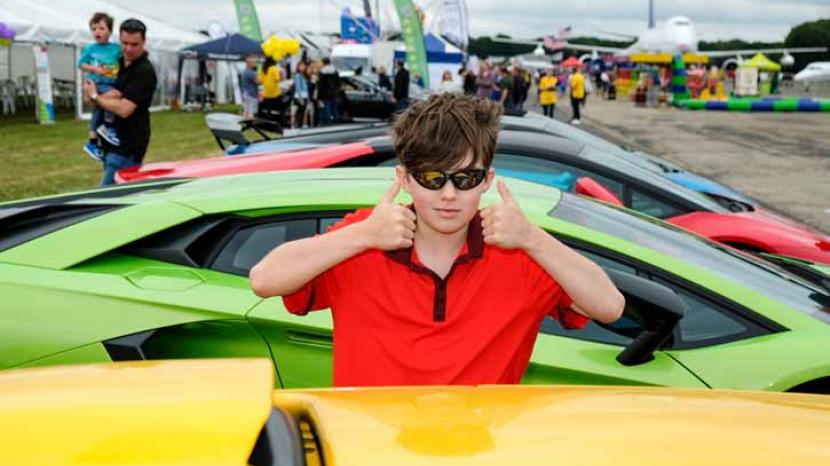 A child giving the camera a "thumbs up" at the Supercar Event
