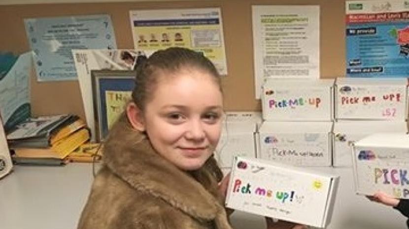 heidi: girl holds up box that reads 'pick me up' 