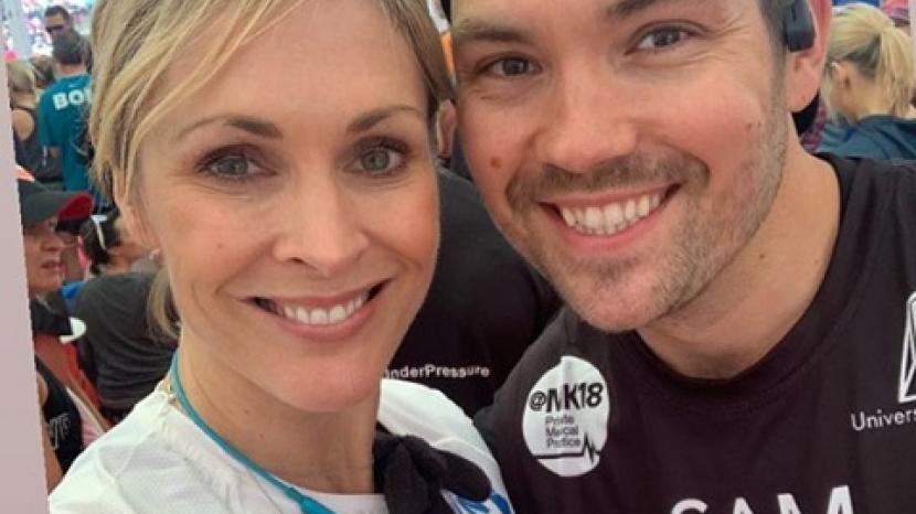 Jenni Falconer and Sam Attwater smile at the camera wearing running gear