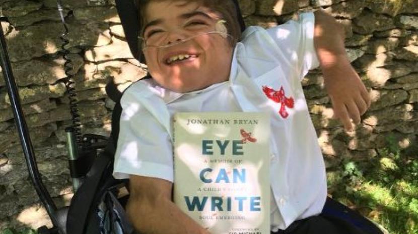 Jonathan holds his book, the title that reads 'eye can write'