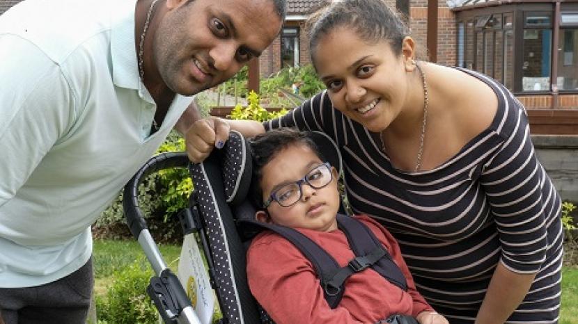 Kai and his parents: young boy in a wheelchair with his mum and dad