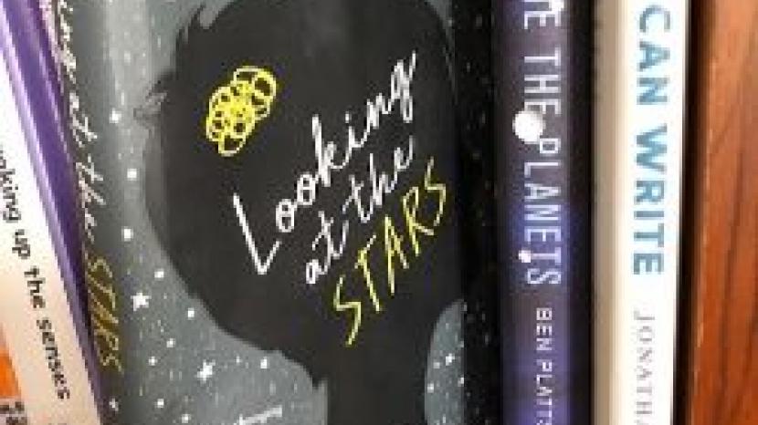 bookshelf with book that reads 'looking at the stars'