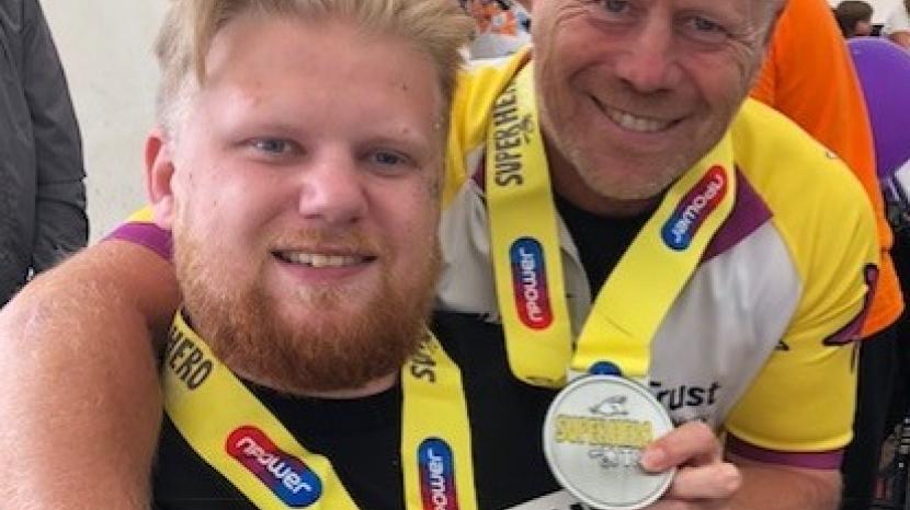 mark and ryan, father and son hold their superhero tri medals 