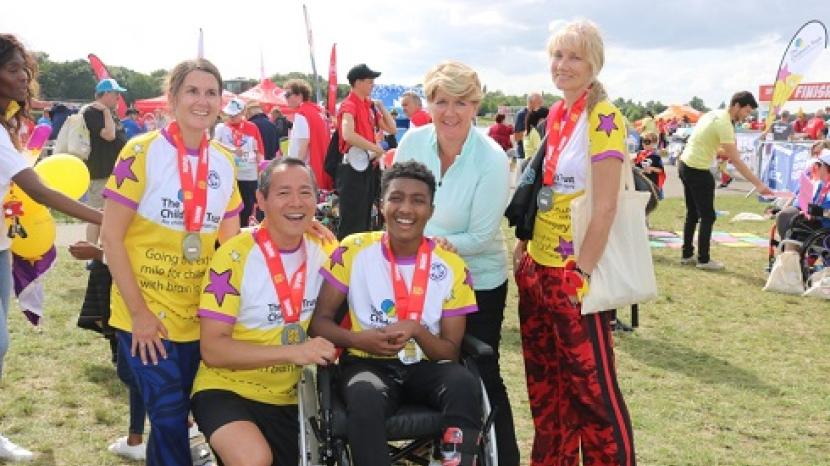 group of people wearing The Children's Trust t-shirts at the finish line of the Superhero Tri