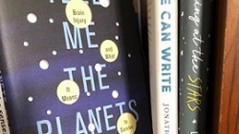 books on a bookshelf, with one titled 'tell me the planets'