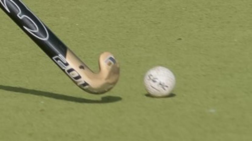 hockey stick and ball on a pitch